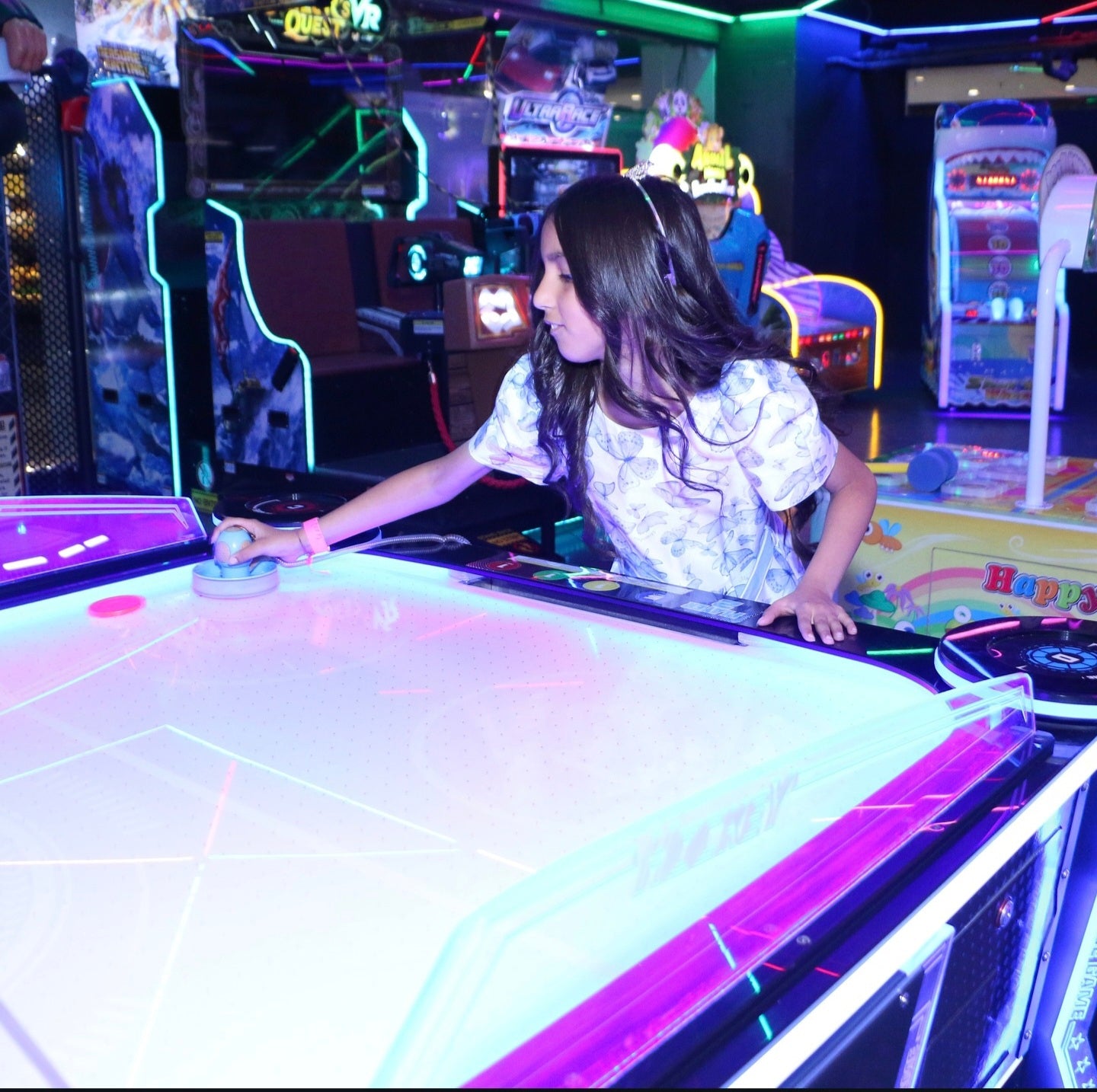 Woman playing air hockey in an arcade setting
