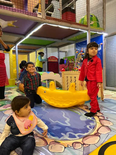 Children engaging with colorful play equipment in a lively indoor activity space at House of Giggles Delhi