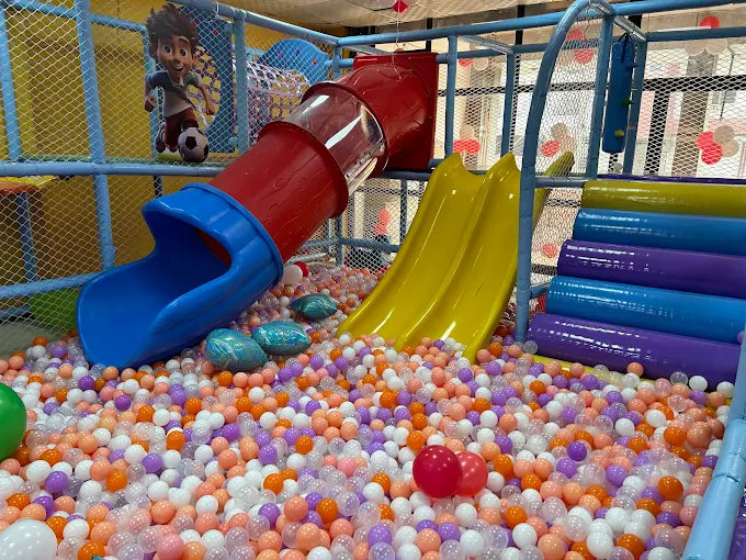 A colorful ball pit with slides and a cartoon character for young children to play in.
