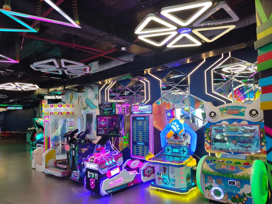 Modern arcade room with vivid neon-lit gaming machines and geometric ceiling lights at Adventure Island Rohini Sector 10