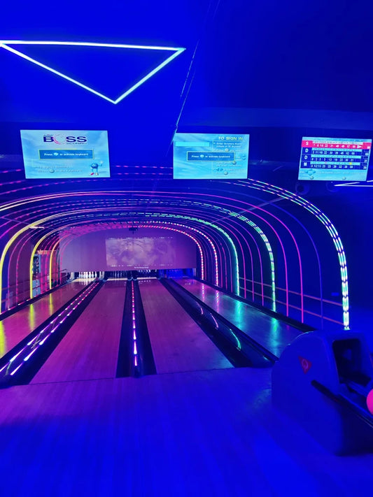 Neon-lit bowling lanes with vibrant arching LED lights and digital scoreboards at Viking Gaming Zone Karkardooma Delhi
