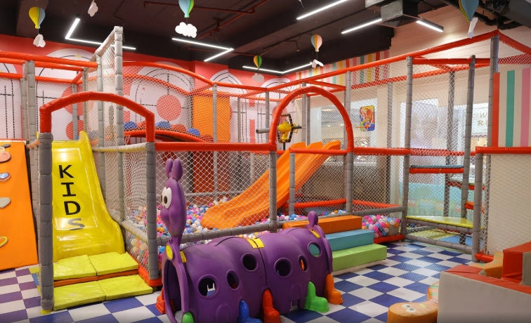 A colorful indoor playground with slides, ball pits, and climbing structures for children.
