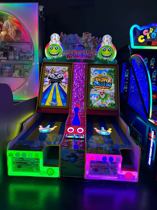 Two brightly lit "Adventure Bowling" arcade games for children, with cartoon characters and colorful displays.