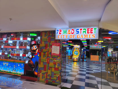 An arcade called "72 Mad Street City of Games" with colorful game machines and a Mario character.