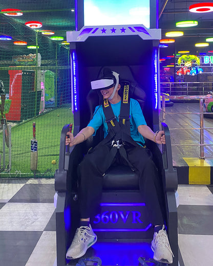 A young person in a VR headset sits in a gaming chair at an arcade.