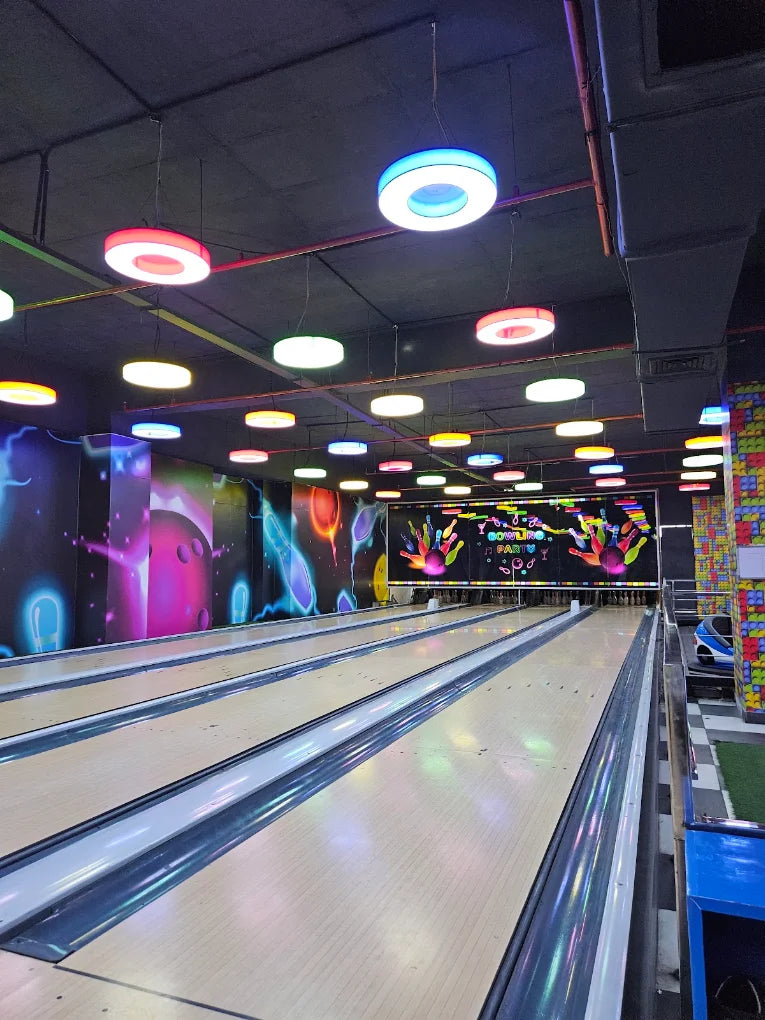 Bowling alley with colorful lights and vibrant murals.