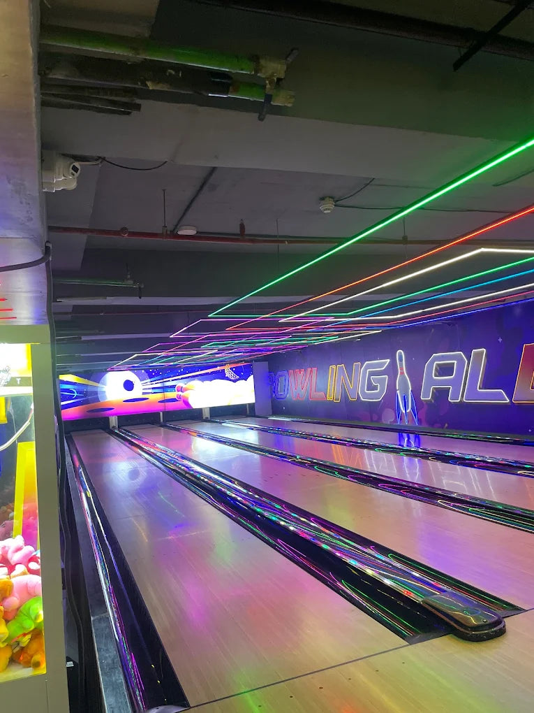 Bowling alley with neon lights and a claw machine.