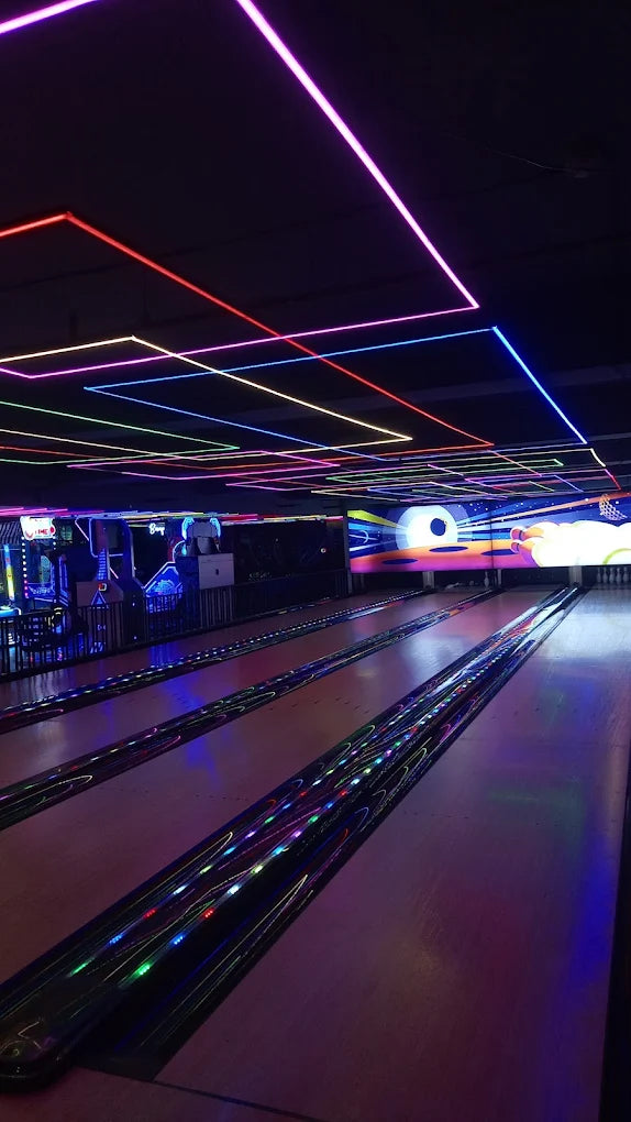 A bowling alley with neon lights and arcade games.