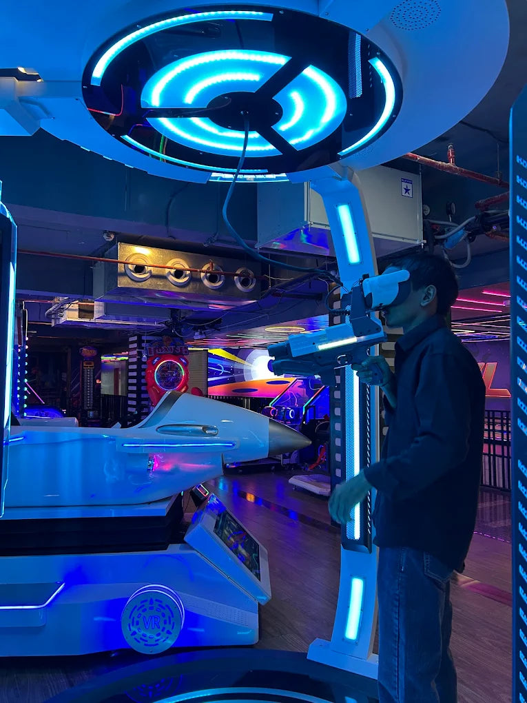 A young person plays a VR game in an arcade, holding a gun and wearing a headset.