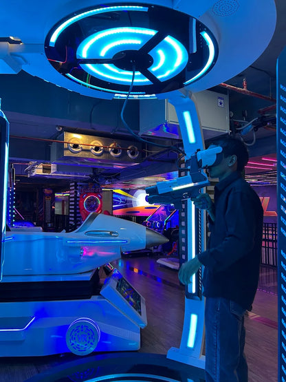 A young person plays a VR game in an arcade, holding a gun and wearing a headset.