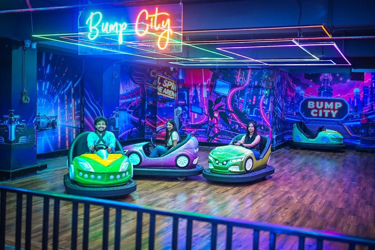 Young adults enjoy bumper cars in a neon-lit arcade with a cityscape mural.