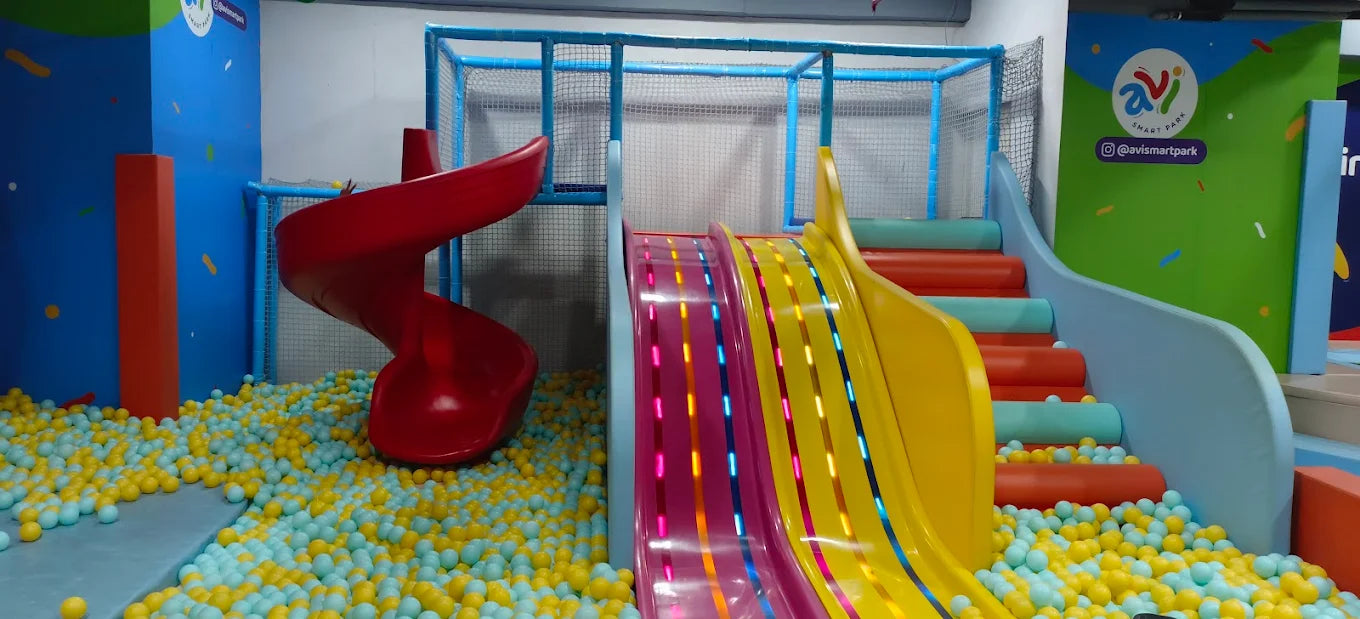 A colorful indoor playground with slides and a ball pit, designed for children.