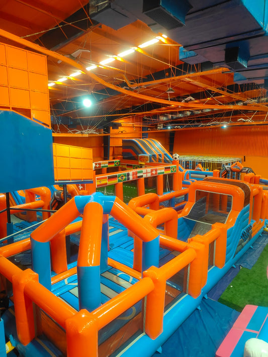 An indoor inflatable obstacle course with orange and blue structures, suitable for children.