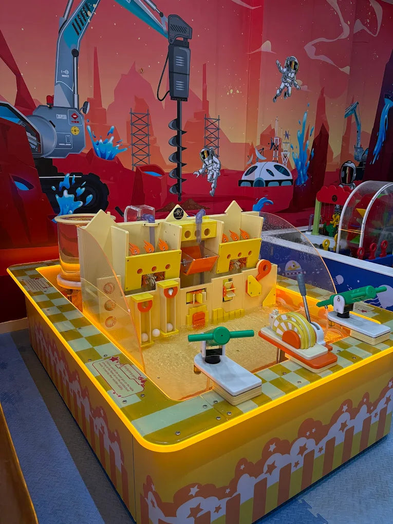A colorful water play table with an outer space theme, featuring astronauts and a large excavator, designed for children.