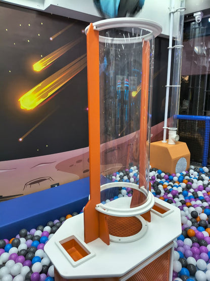 A children's ball pit with a space-themed mural and a clear tube attraction.