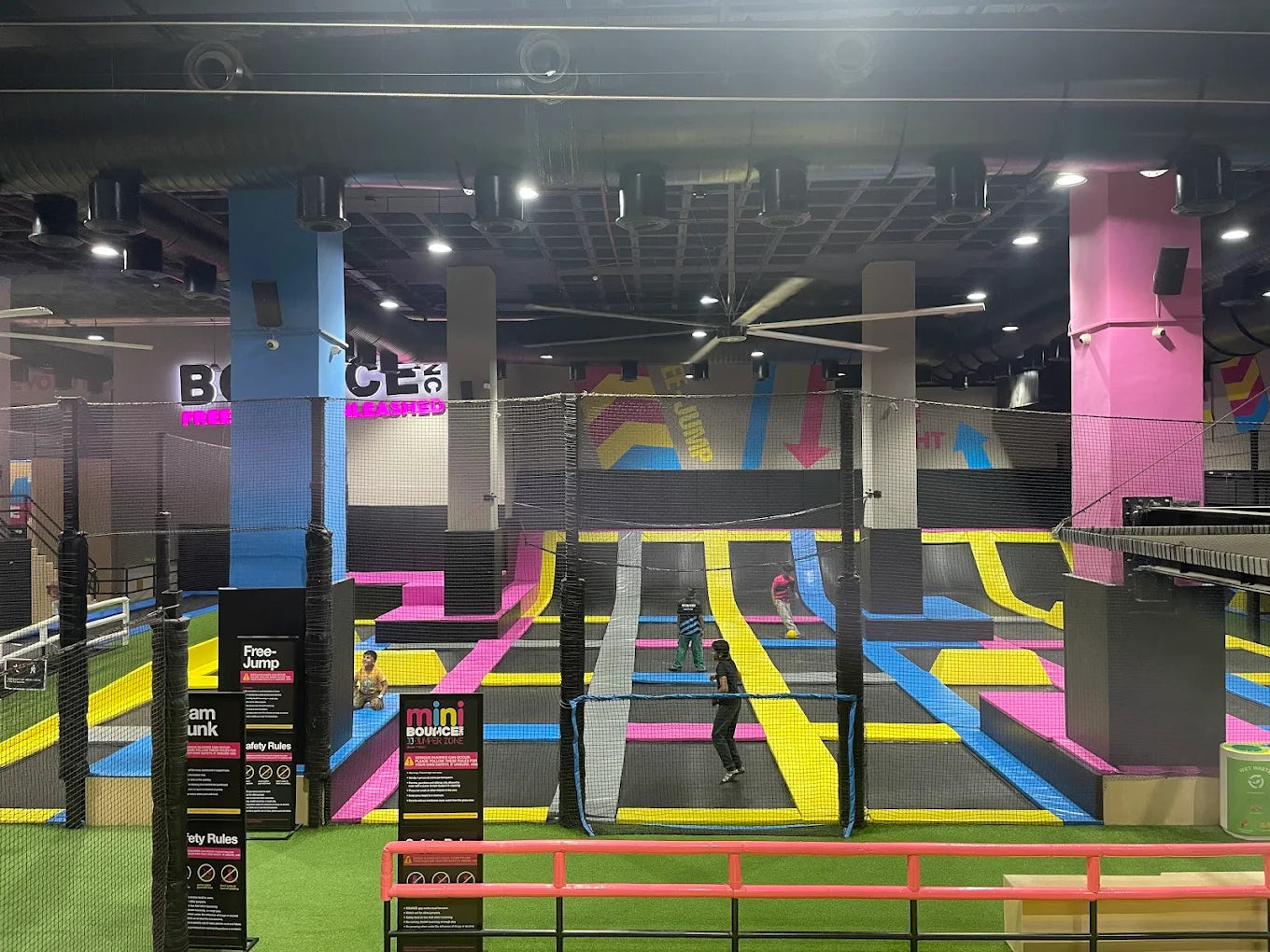 Children jump and play on colorful trampolines in an indoor trampoline park.