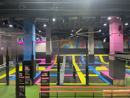 Children jump and play on colorful trampolines in an indoor trampoline park.