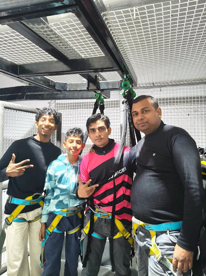 Four young people in harnesses ready for an adventure activity.