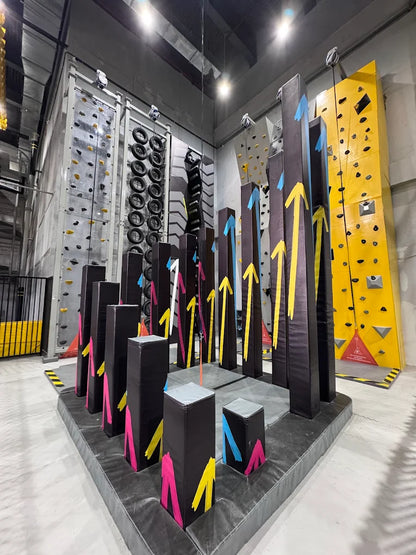 An indoor climbing gym with various climbing walls and obstacle courses.