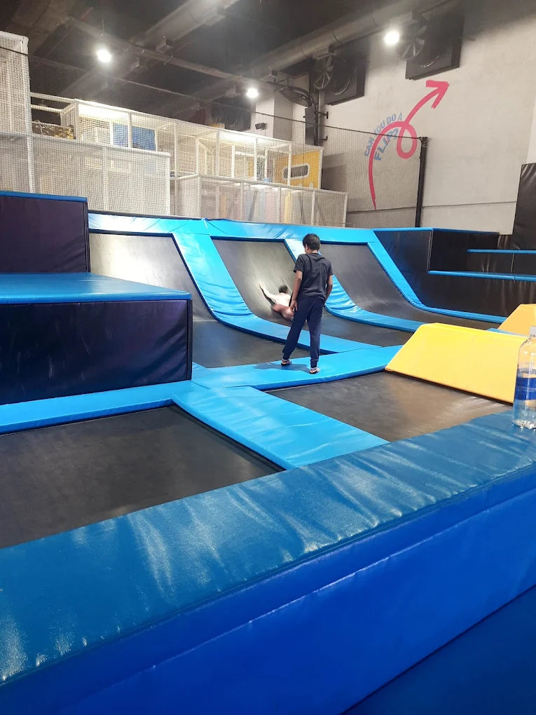 Children play on trampolines in an indoor park.
