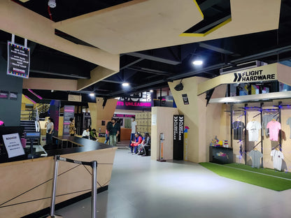An indoor trampoline park with people at the reception and a merchandise display.
