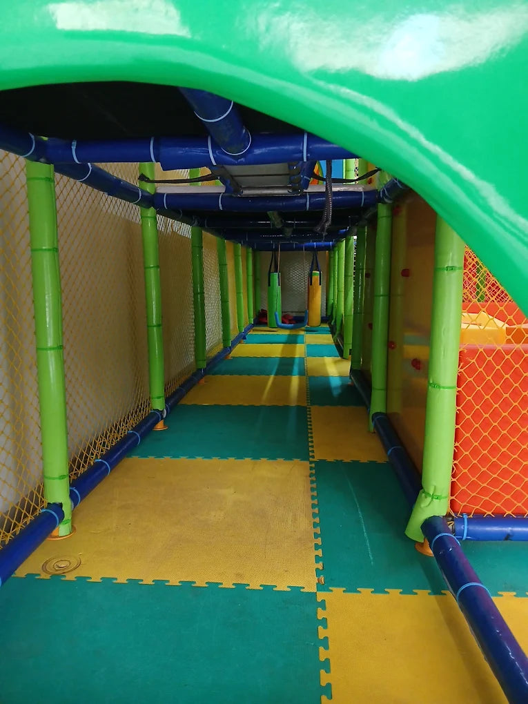 A colorful indoor playground with soft flooring and climbing structures.