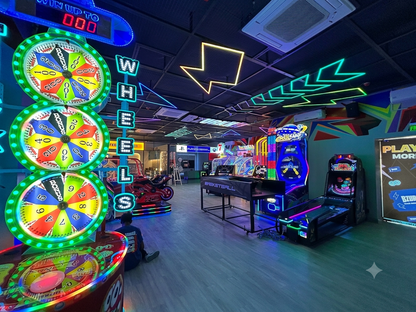 An arcade with colorful games and neon lights, featuring a child sitting on the floor.