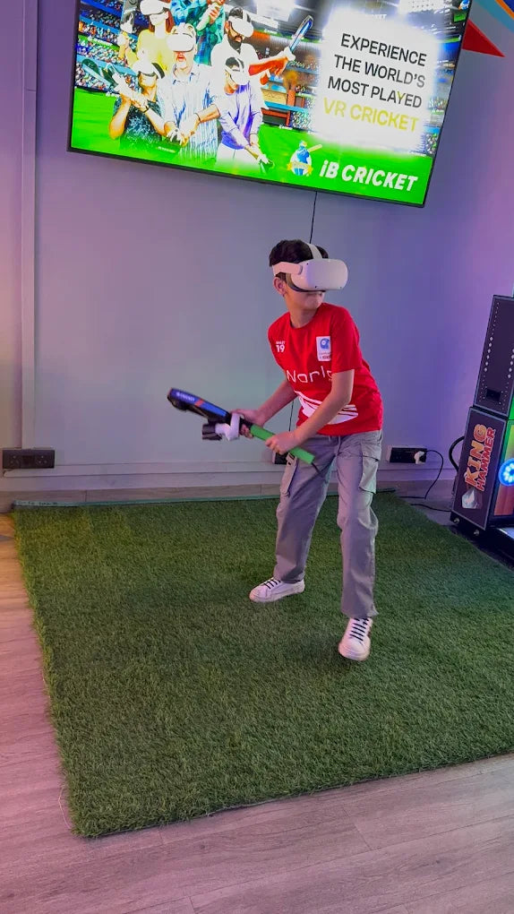 A young boy wearing a VR headset plays a virtual reality cricket game. He holds a controller shaped like a cricket bat.