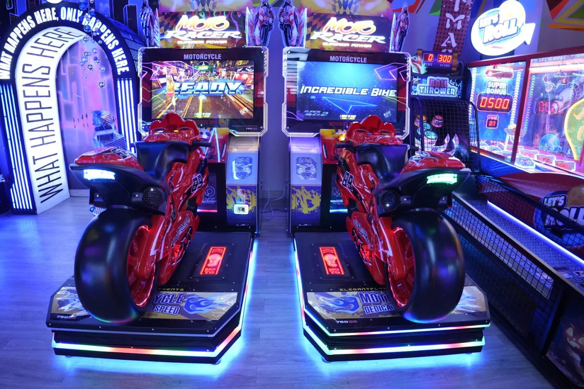Two red motorcycle arcade games are lit up in an arcade.