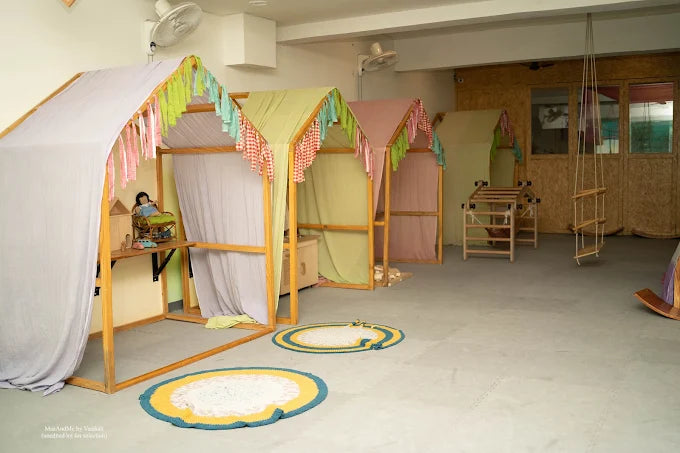 Children's playroom with colorful playhouses and toys on a light gray floor.