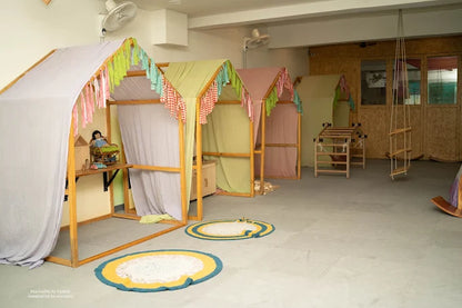 Children's playroom with colorful playhouses and toys on a light gray floor.