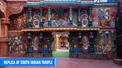 A vibrant replica of a South Indian temple entrance, adorned with colorful murals and statues, with people in the background.