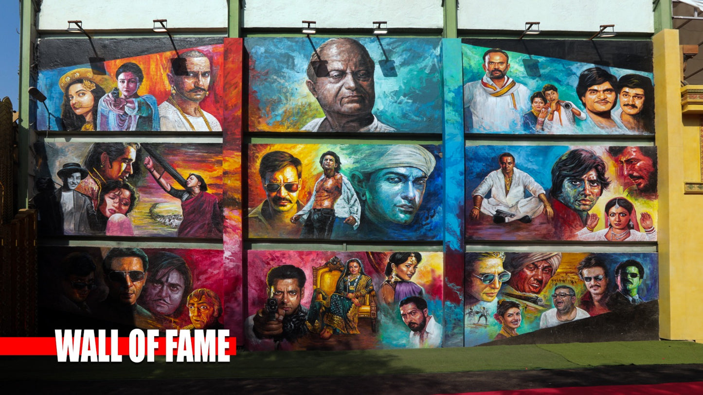 A mural on a wall depicts portraits of actors from different eras. The mural is titled "WALL OF FAME".
