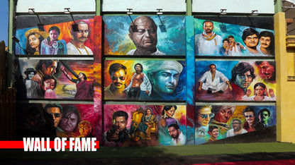 A mural on a wall depicts portraits of actors from different eras. The mural is titled "WALL OF FAME".