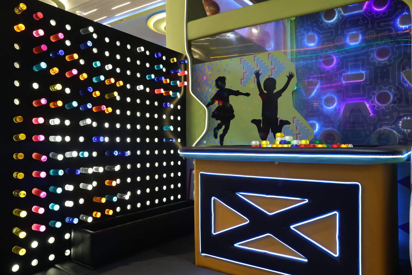 Children's play area with a light-up pegboard and a digital game screen featuring silhouettes of kids.