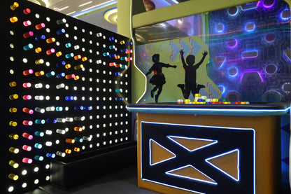 Children's play area with a light-up pegboard and a digital game screen featuring silhouettes of kids.