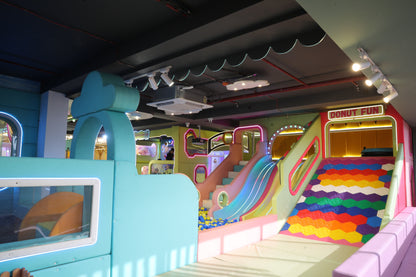 A colorful indoor playground with slides and a ball pit, featuring a "Donut Fun" sign.
