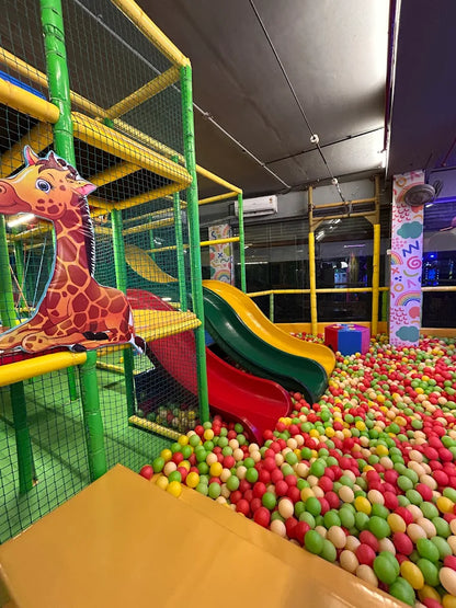 A colorful ball pit with slides and a giraffe cutout in a children's play area.