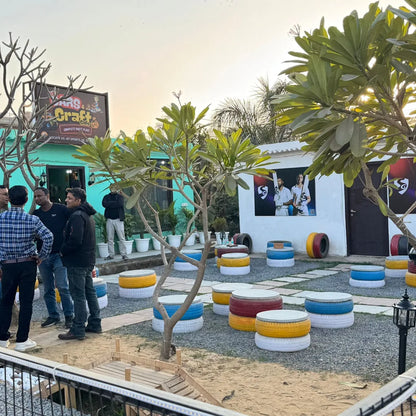 An outdoor cafe with tire seating and a mural of cricketers.