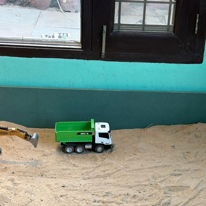 Toy dump truck and excavator in a sandbox.