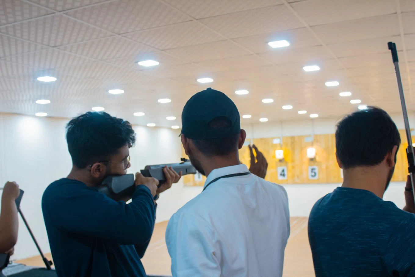 Young men practice shooting at a target range.
