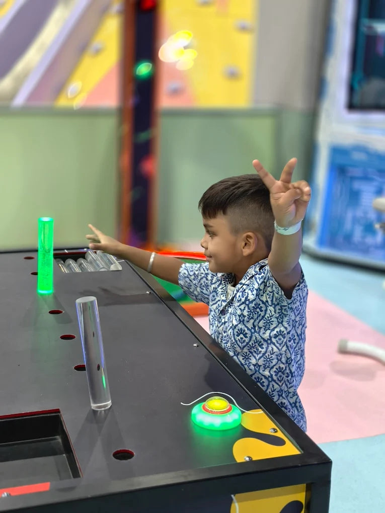 A young boy plays an interactive game with flashing lights at an arcade.