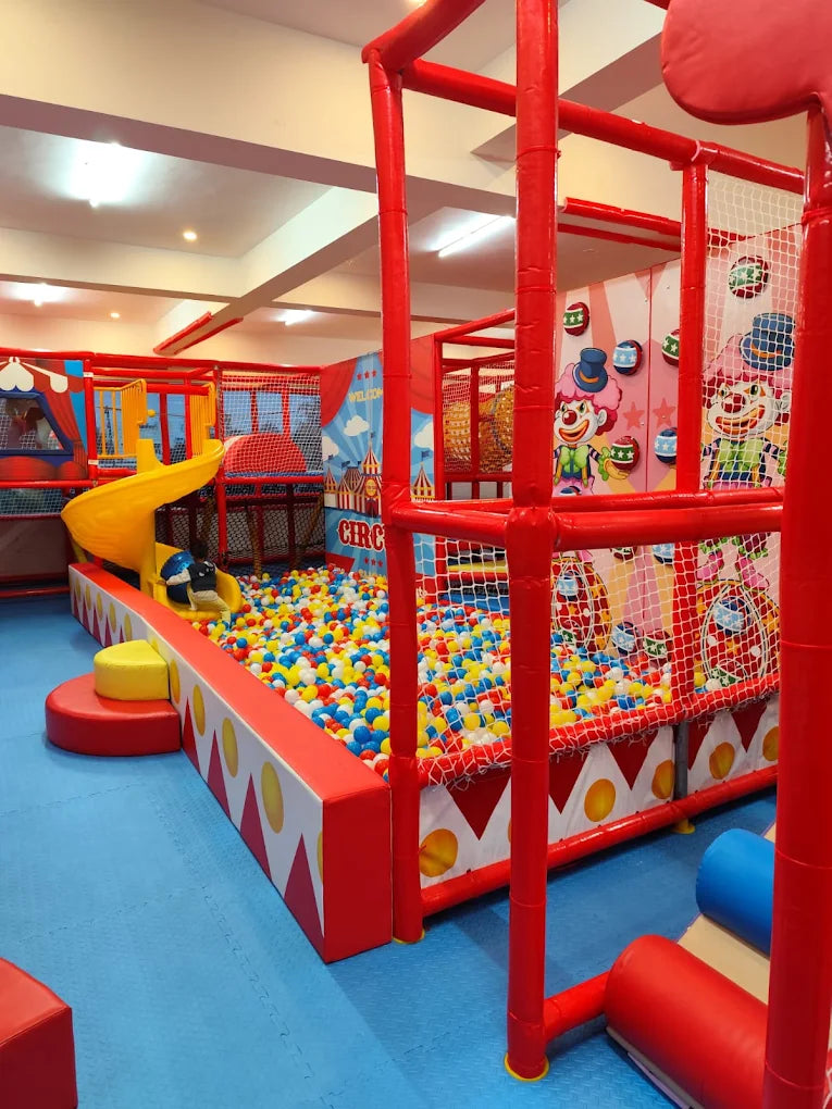 A colorful indoor playground with a ball pit, slides, and climbing structures for children.