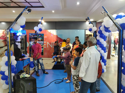 People of various ages enjoy a virtual reality experience at an indoor event with balloons.