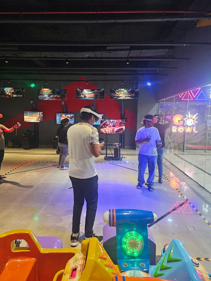 Young adults play virtual reality games in an arcade.