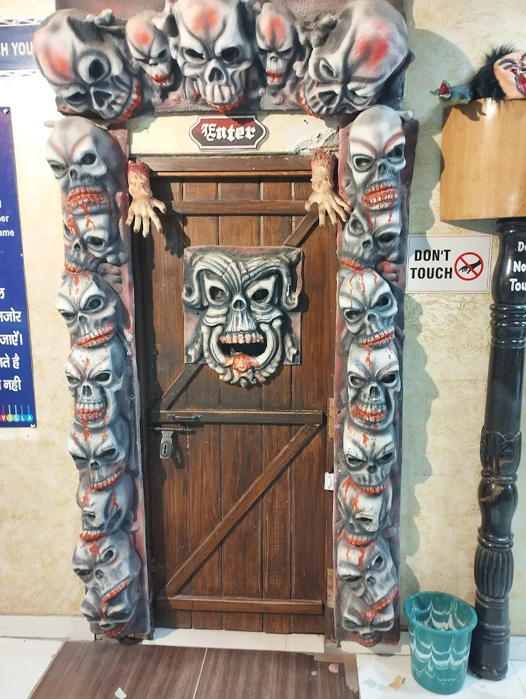 A spooky doorway decorated with skulls and a sign that says "Enter."