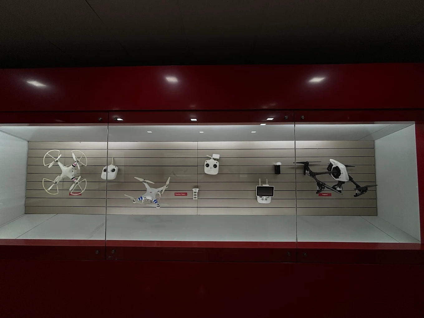 A display case with several drones and controllers.