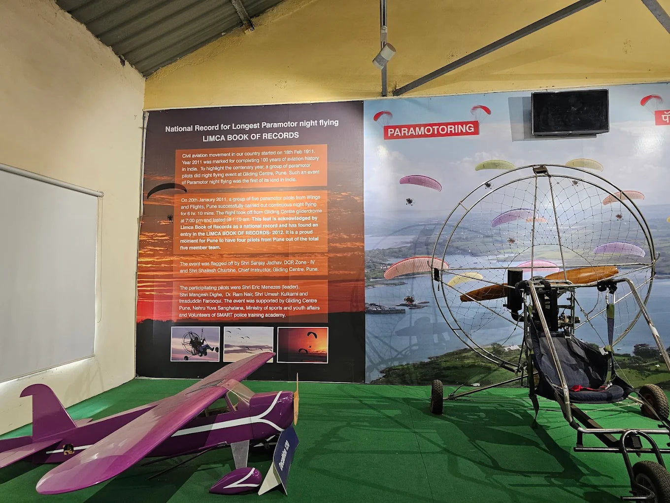Paramotoring display with a purple airplane and a paramotor rig.