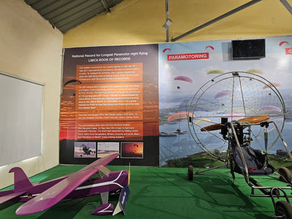 Paramotoring display with a purple airplane and a paramotor rig.