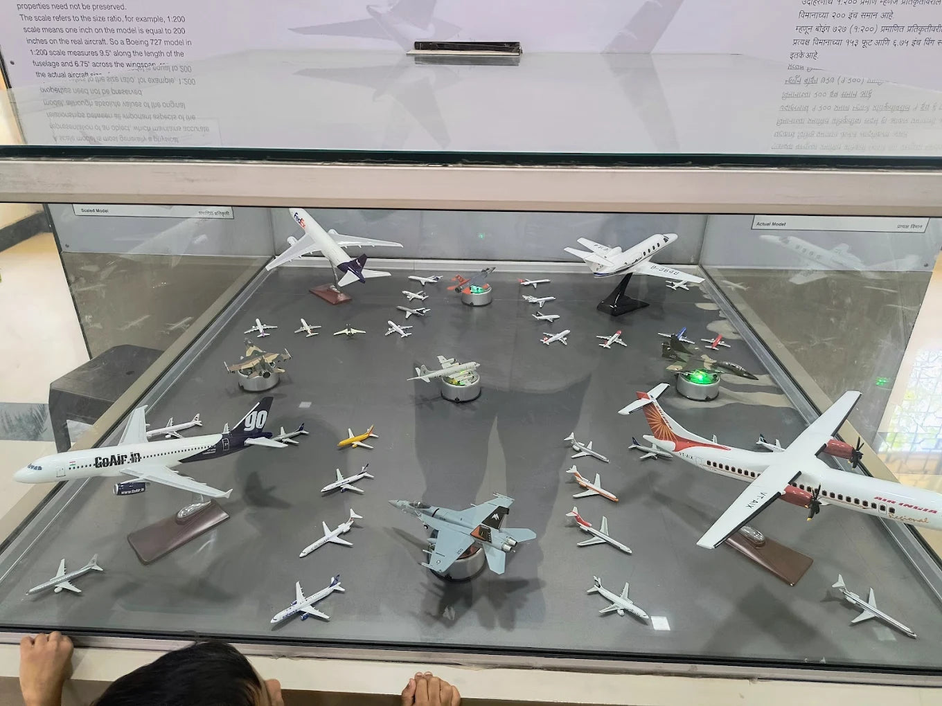 A child looks at a display of model airplanes in a museum.